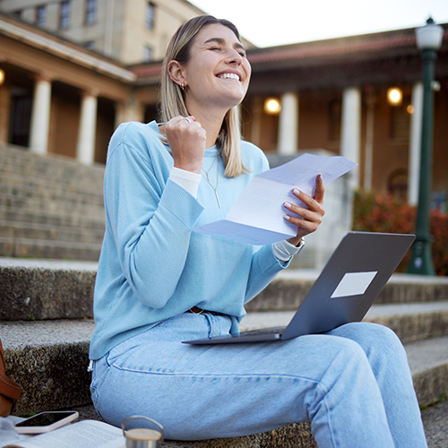 Excited student holding documents